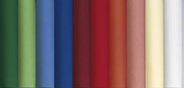 Eight shirts arranged on table in black, olive, grey, blue, white, red, mustard, and green.