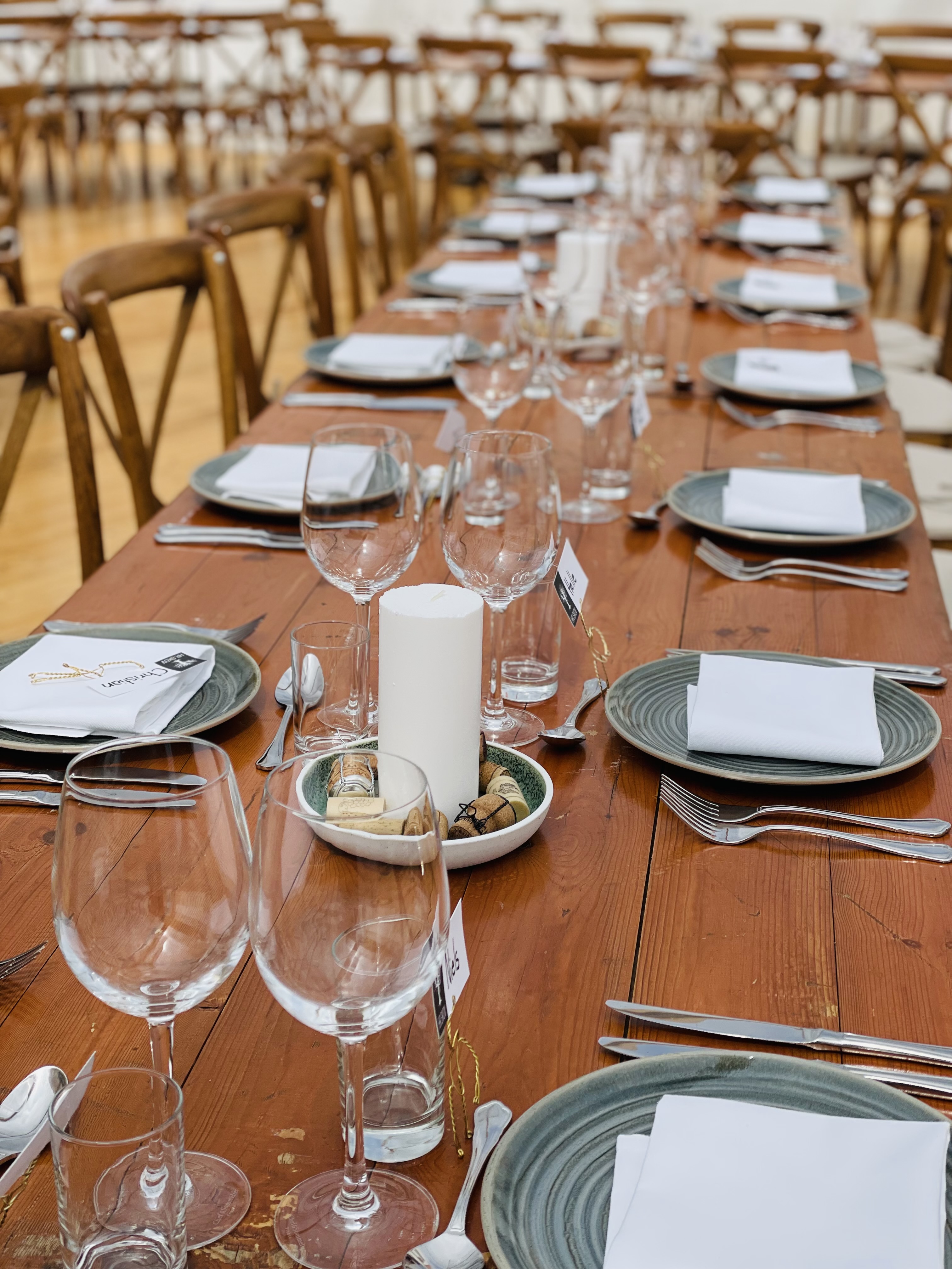 Eight shirts arranged on table in black, olive, grey, blue, white, red, mustard, and green.