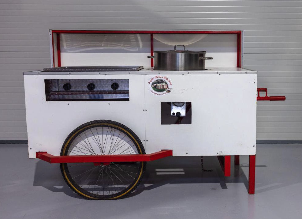 Eight shirts arranged on table in black, olive, grey, blue, white, red, mustard, and green.