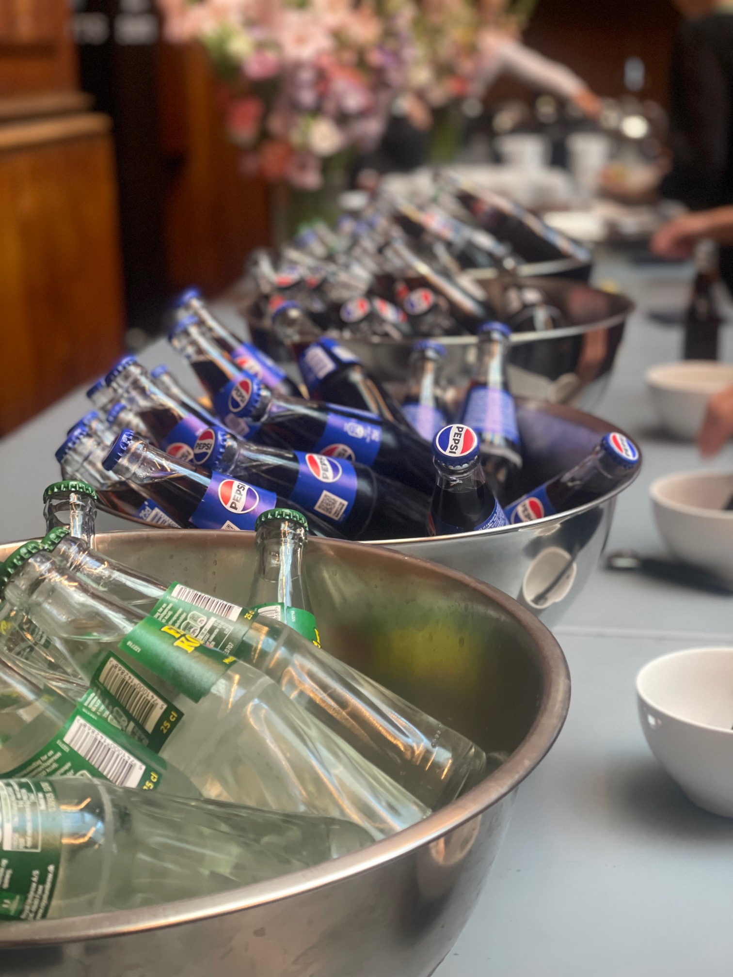 Eight shirts arranged on table in black, olive, grey, blue, white, red, mustard, and green.