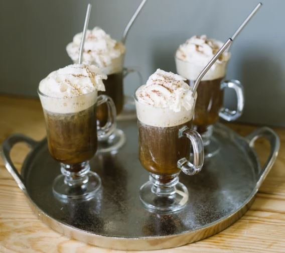 Eight shirts arranged on table in black, olive, grey, blue, white, red, mustard, and green.