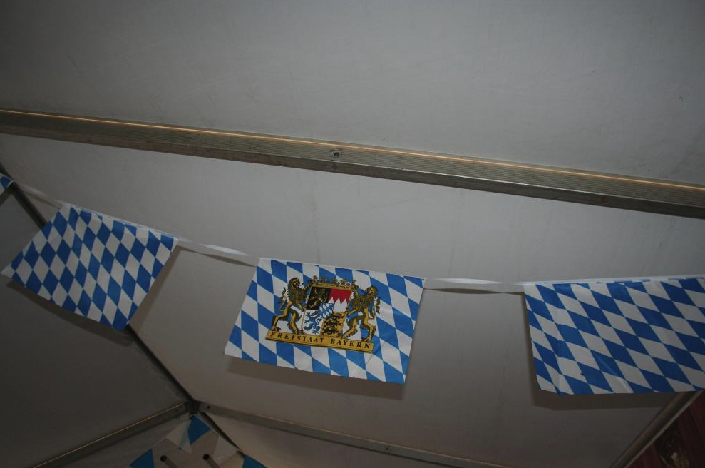 Eight shirts arranged on table in black, olive, grey, blue, white, red, mustard, and green.