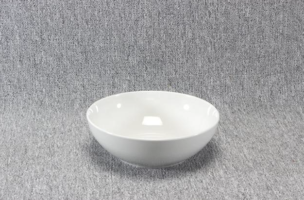 Eight shirts arranged on table in black, olive, grey, blue, white, red, mustard, and green.