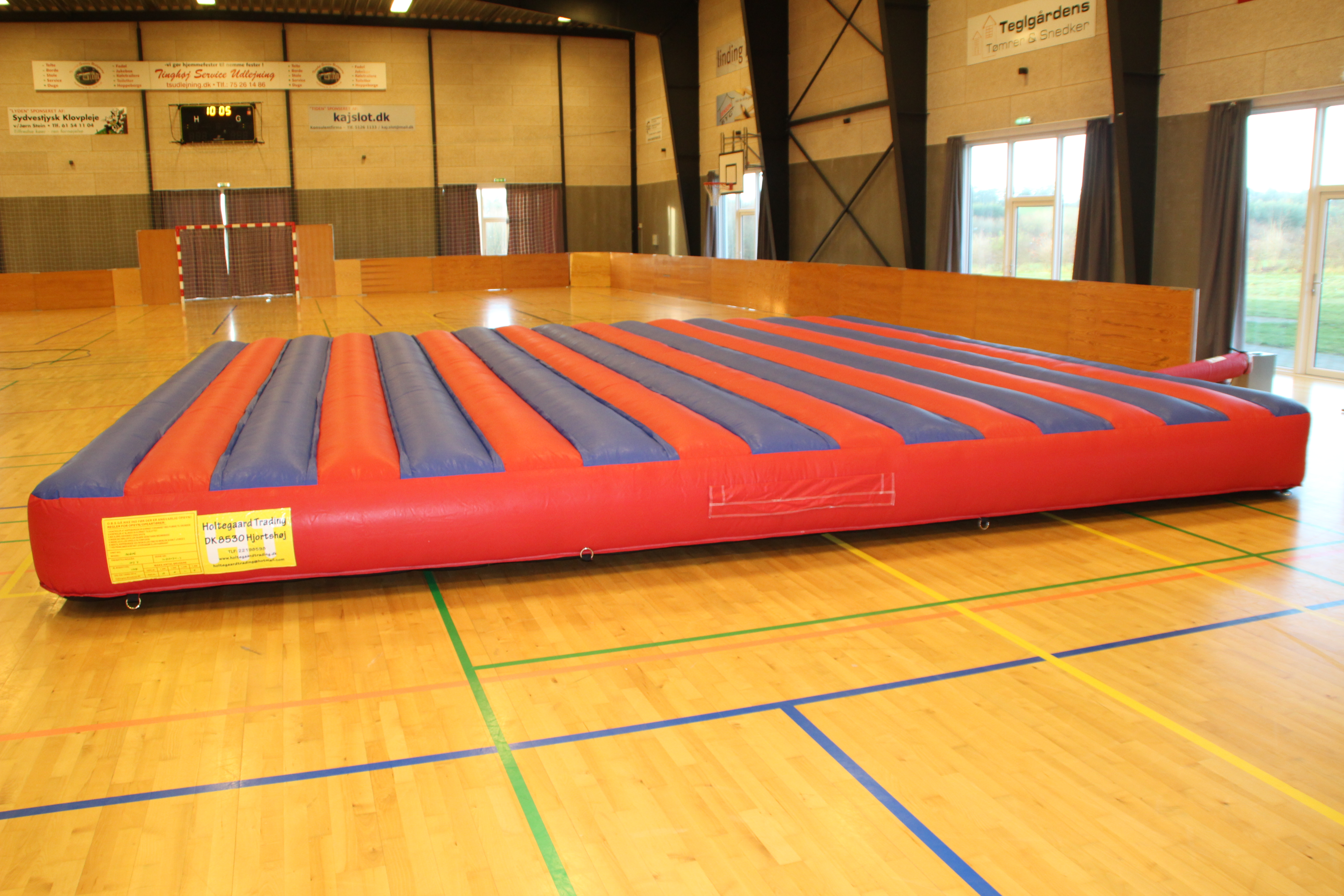 Eight shirts arranged on table in black, olive, grey, blue, white, red, mustard, and green.