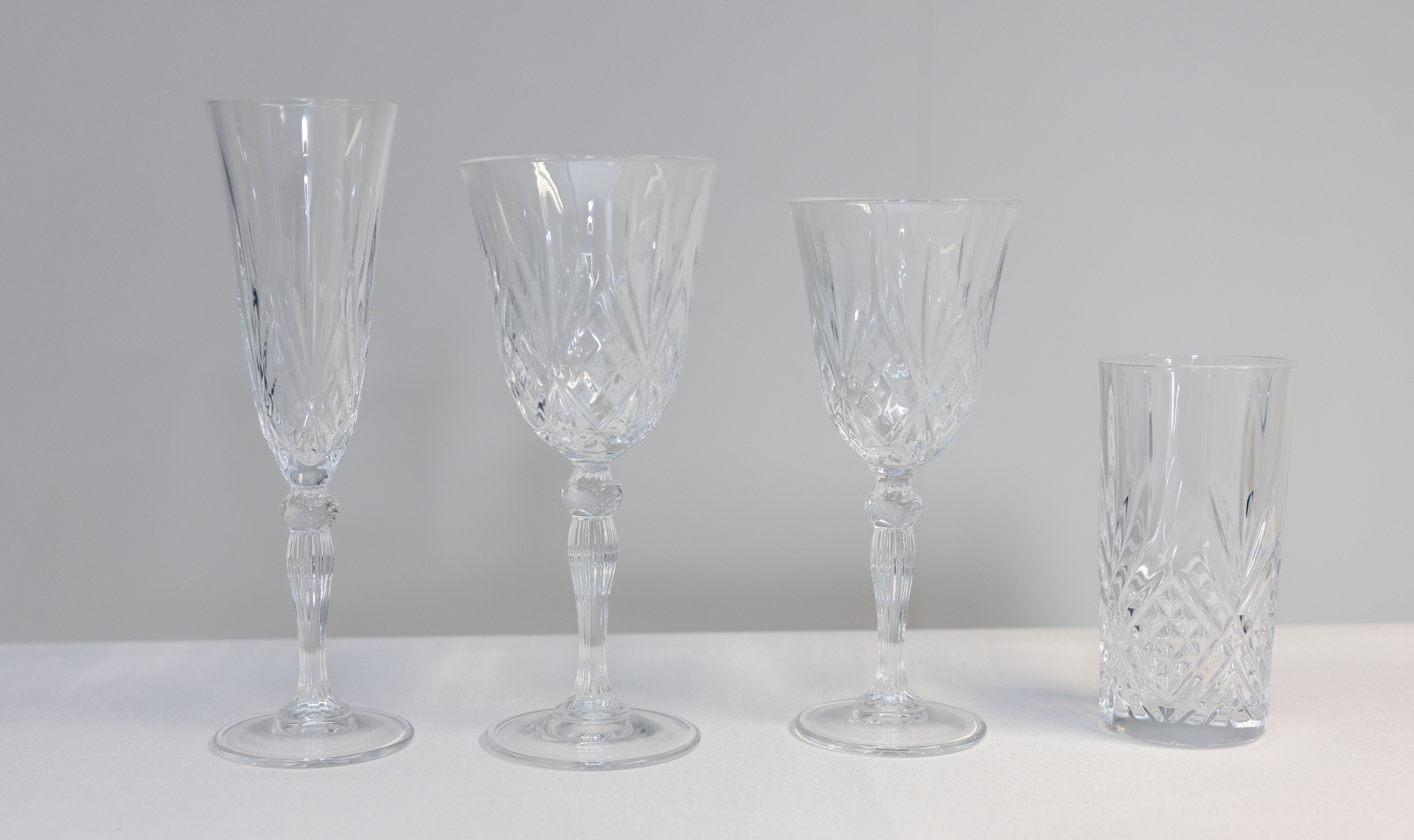 Eight shirts arranged on table in black, olive, grey, blue, white, red, mustard, and green.