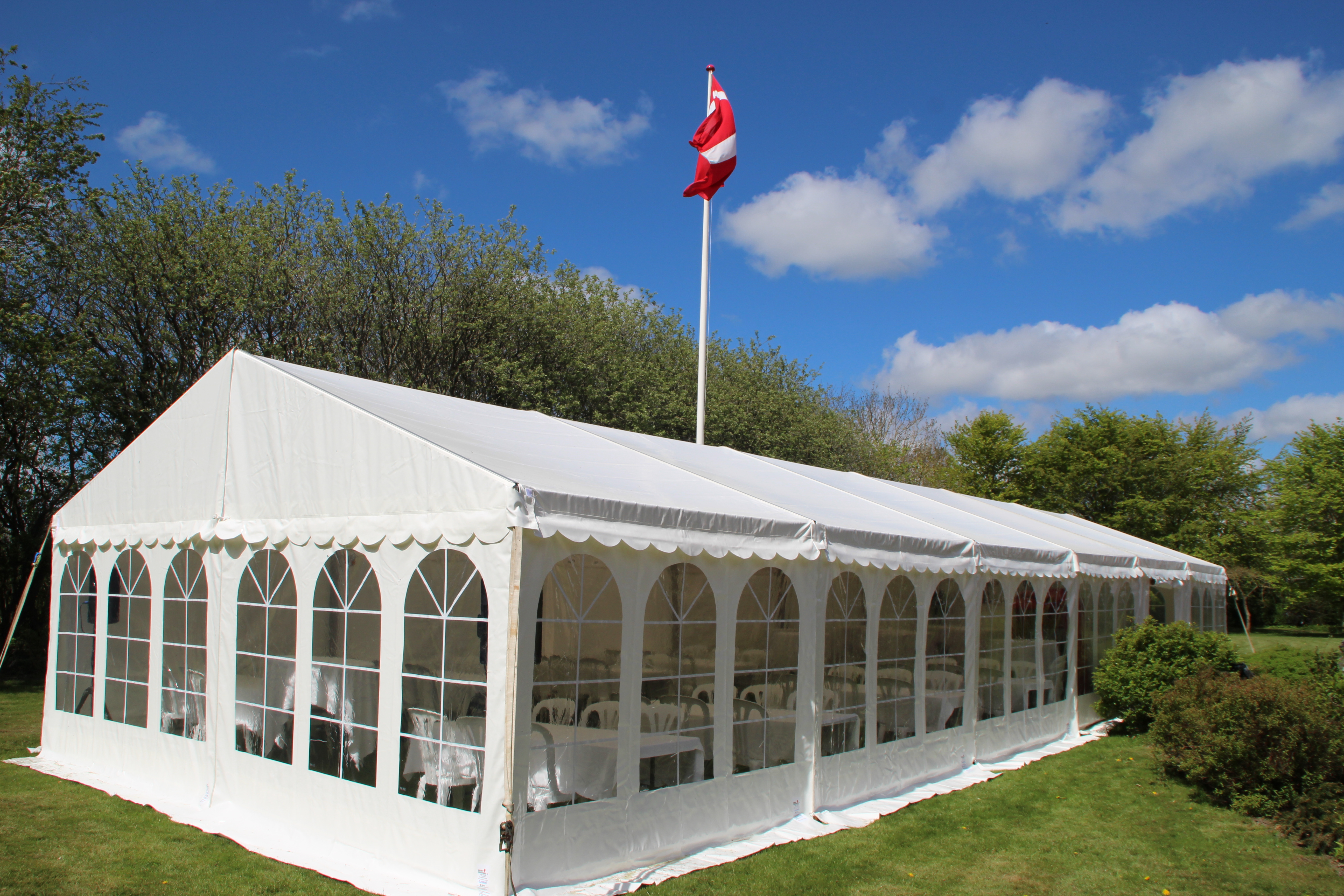 Eight shirts arranged on table in black, olive, grey, blue, white, red, mustard, and green.