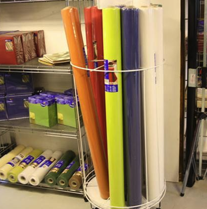 Eight shirts arranged on table in black, olive, grey, blue, white, red, mustard, and green.