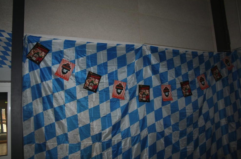 Eight shirts arranged on table in black, olive, grey, blue, white, red, mustard, and green.