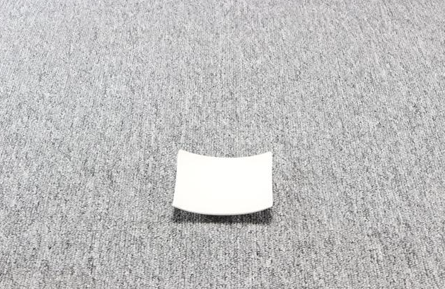 Eight shirts arranged on table in black, olive, grey, blue, white, red, mustard, and green.