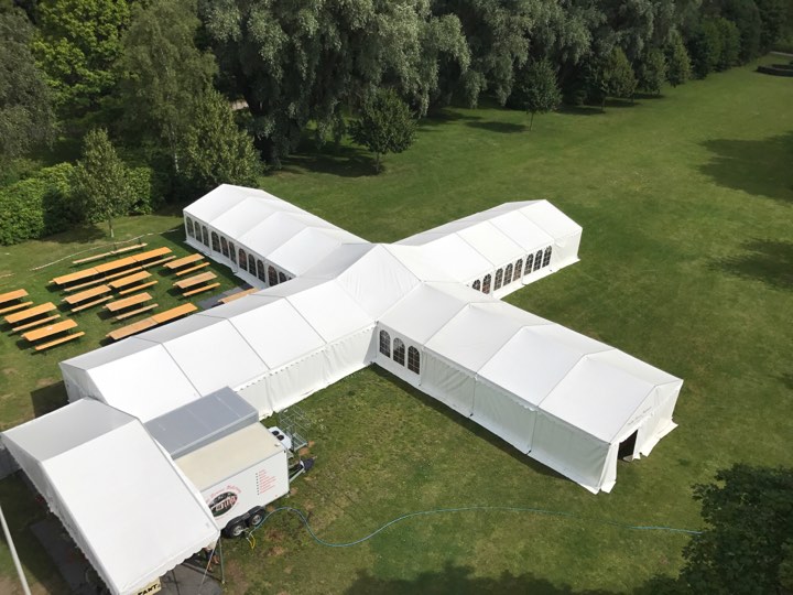 Eight shirts arranged on table in black, olive, grey, blue, white, red, mustard, and green.