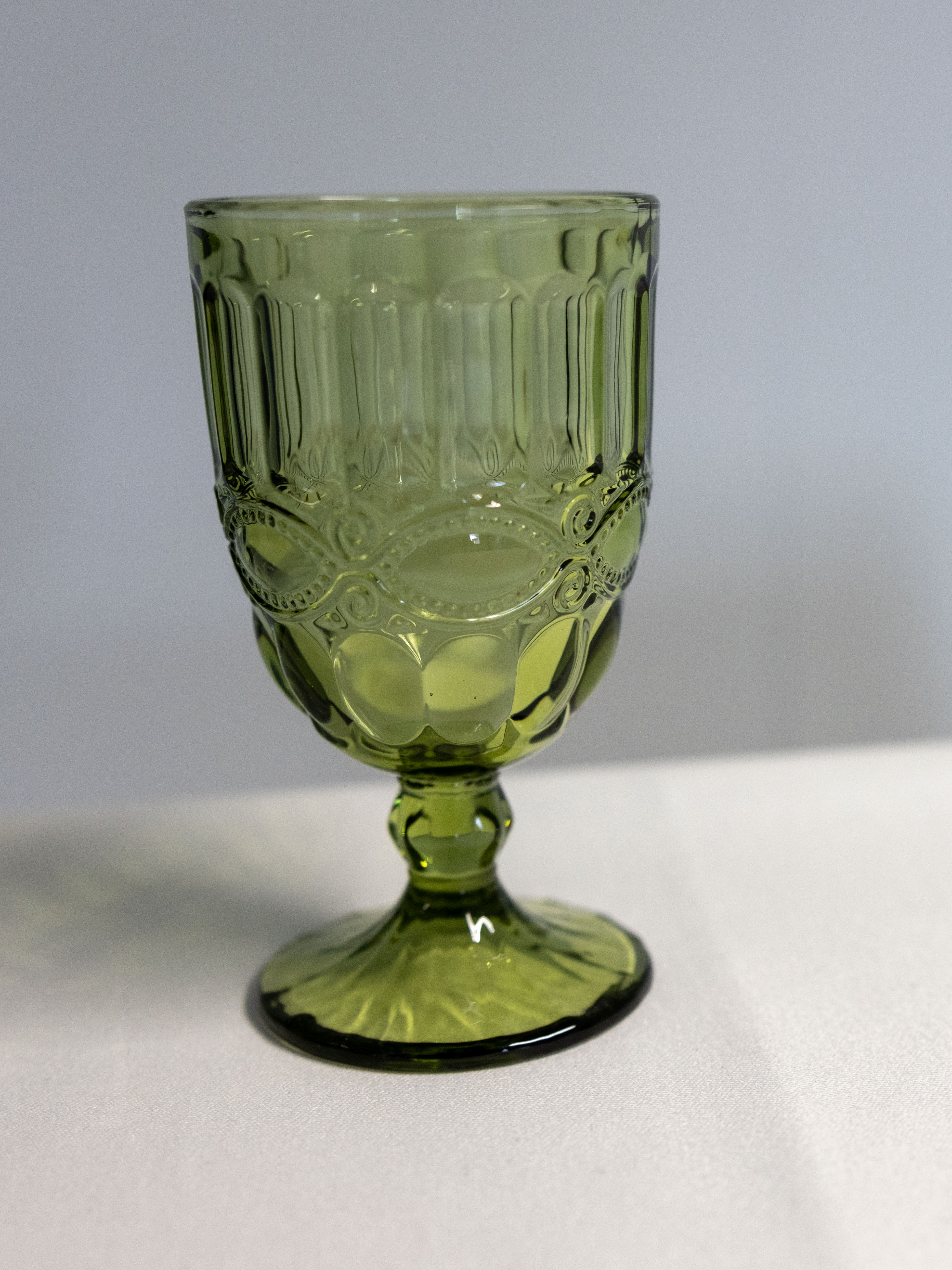 Eight shirts arranged on table in black, olive, grey, blue, white, red, mustard, and green.