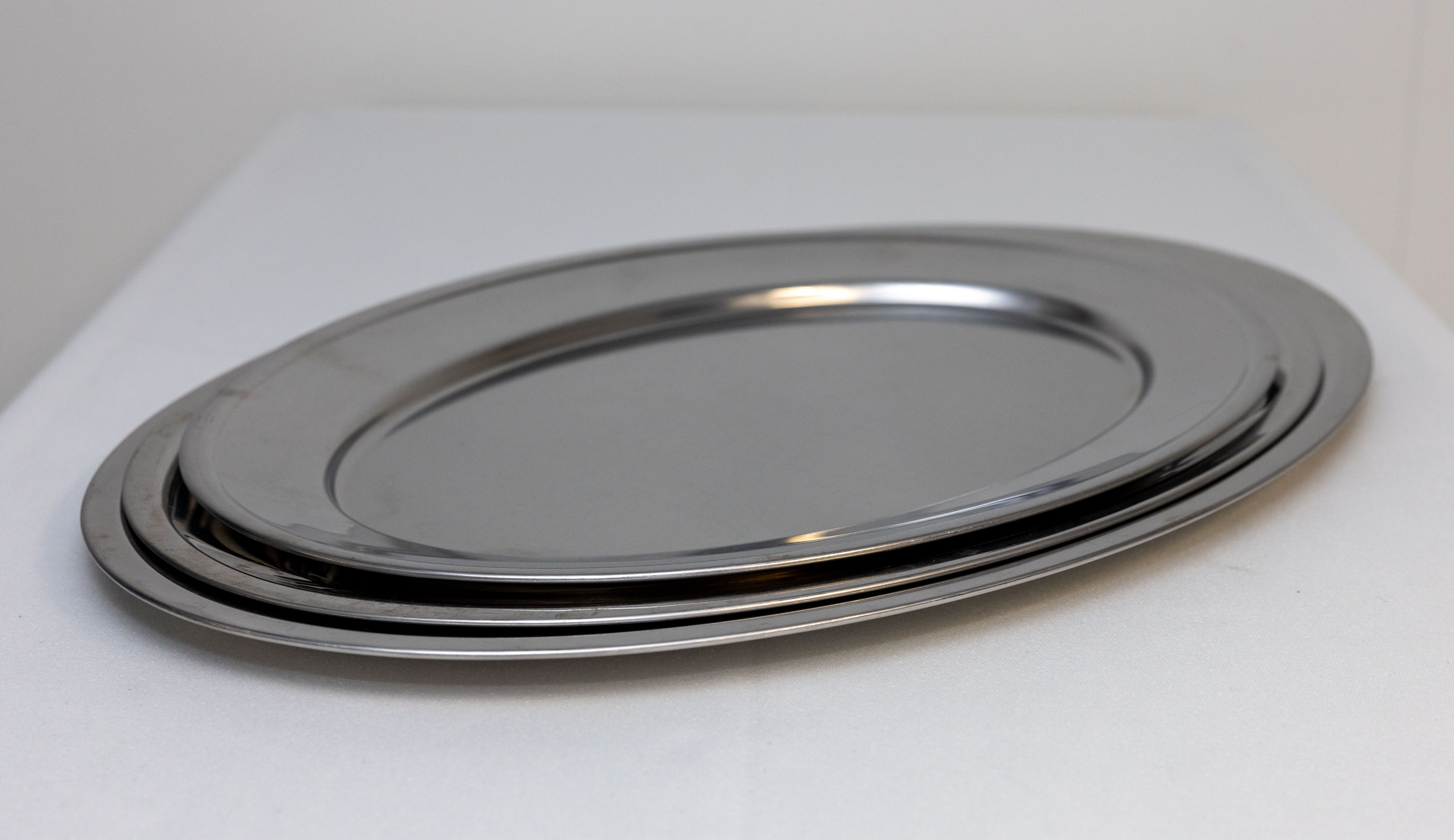 Eight shirts arranged on table in black, olive, grey, blue, white, red, mustard, and green.