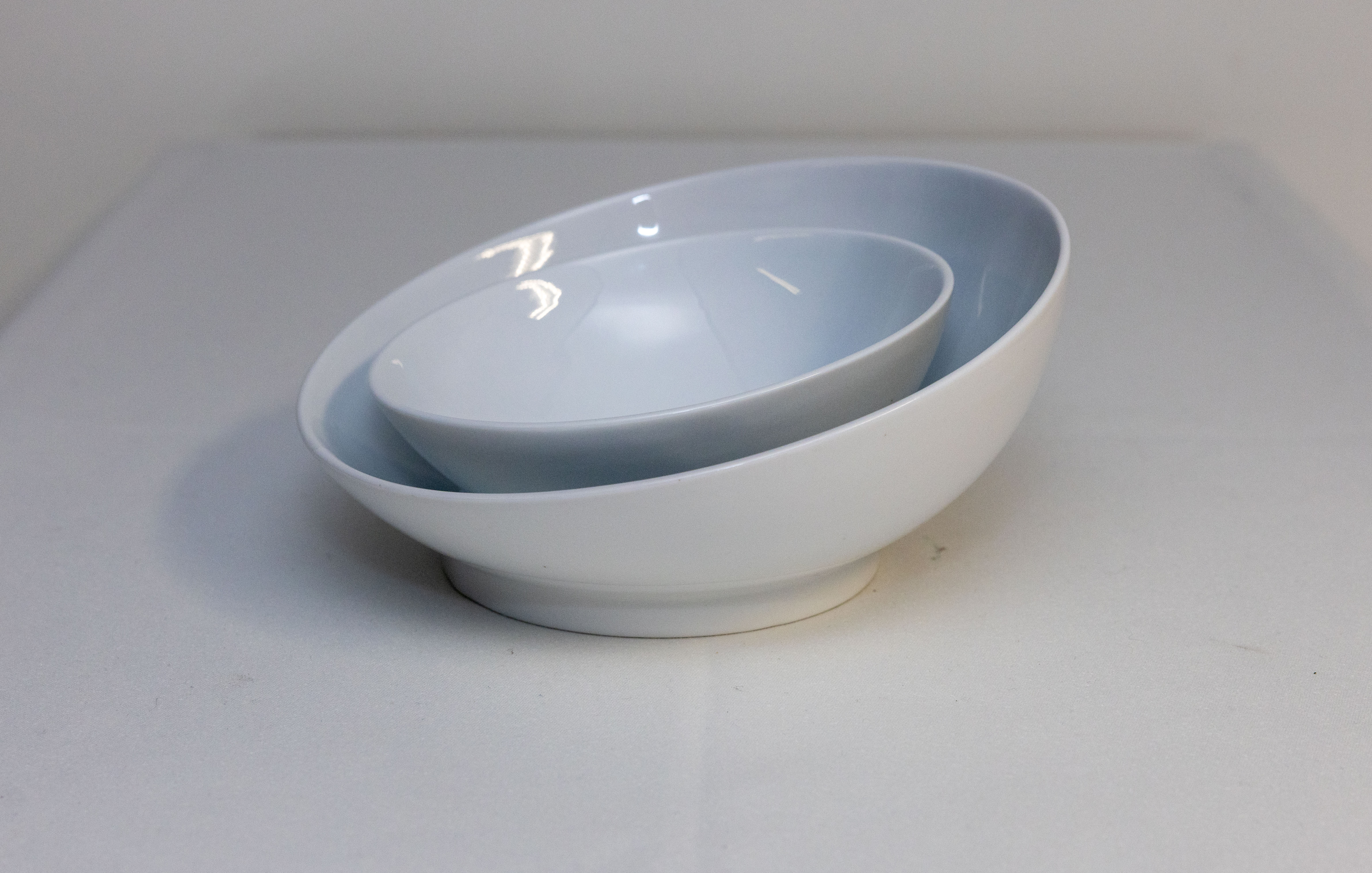 Eight shirts arranged on table in black, olive, grey, blue, white, red, mustard, and green.