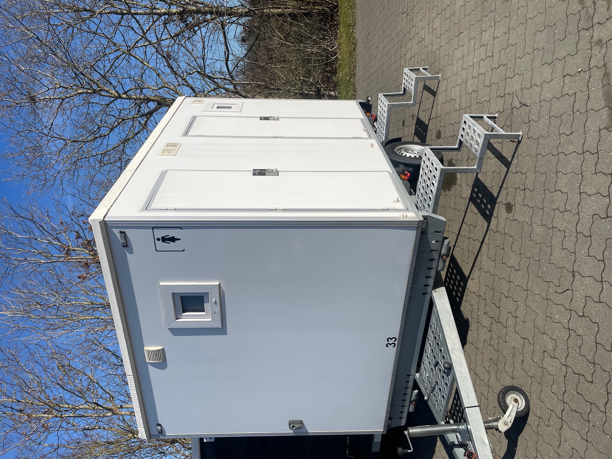 Eight shirts arranged on table in black, olive, grey, blue, white, red, mustard, and green.