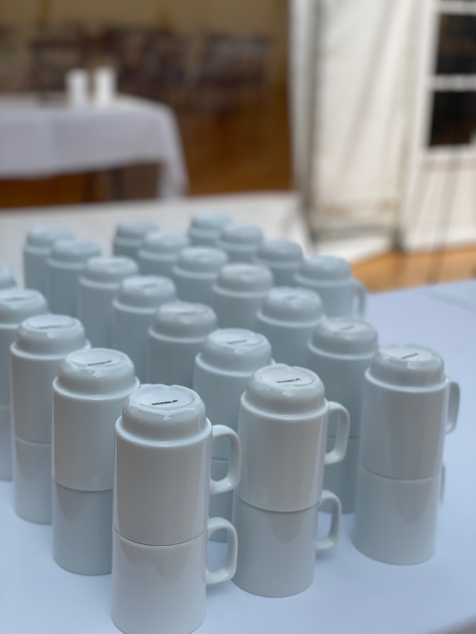 Eight shirts arranged on table in black, olive, grey, blue, white, red, mustard, and green.