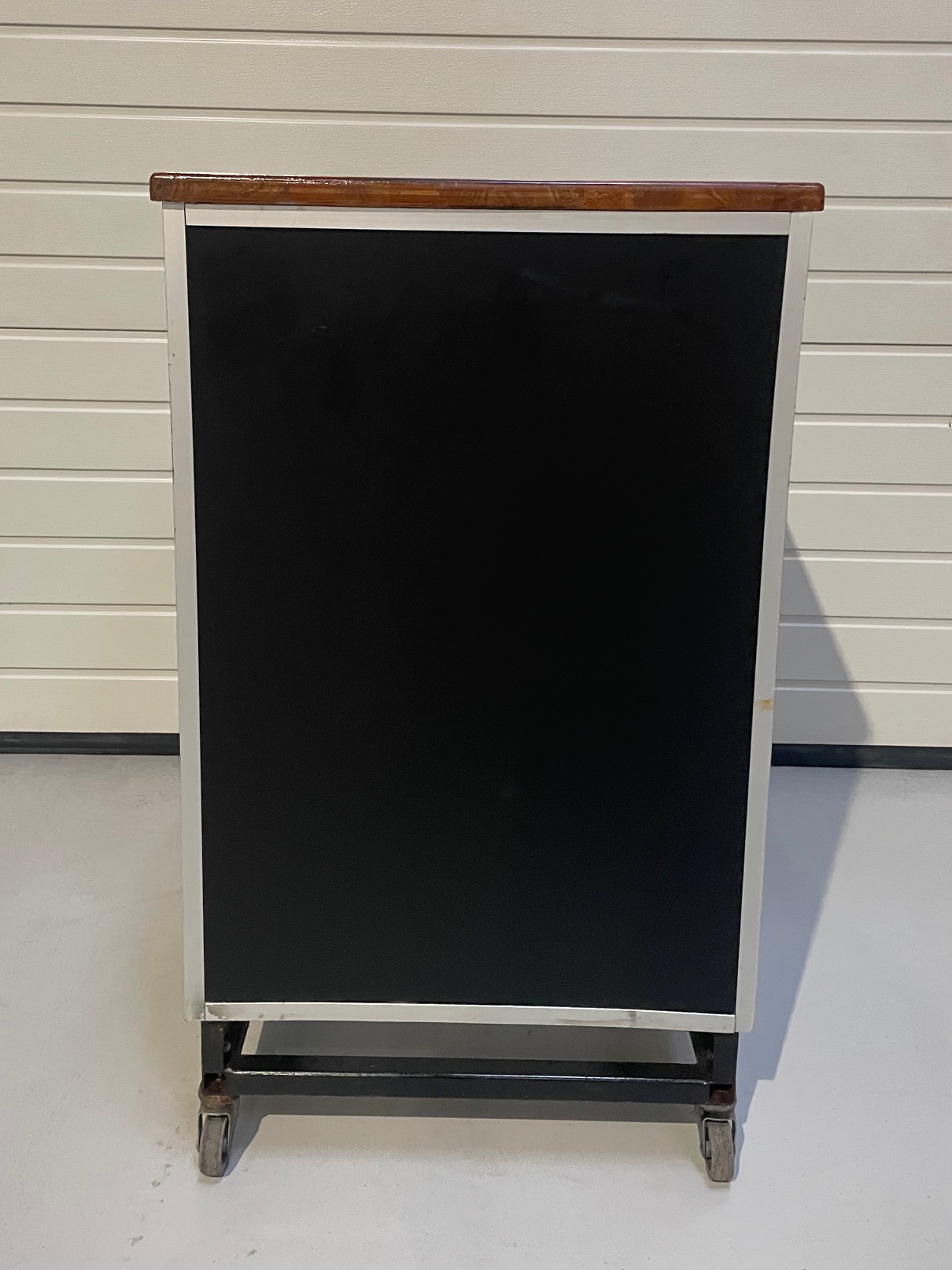 Eight shirts arranged on table in black, olive, grey, blue, white, red, mustard, and green.