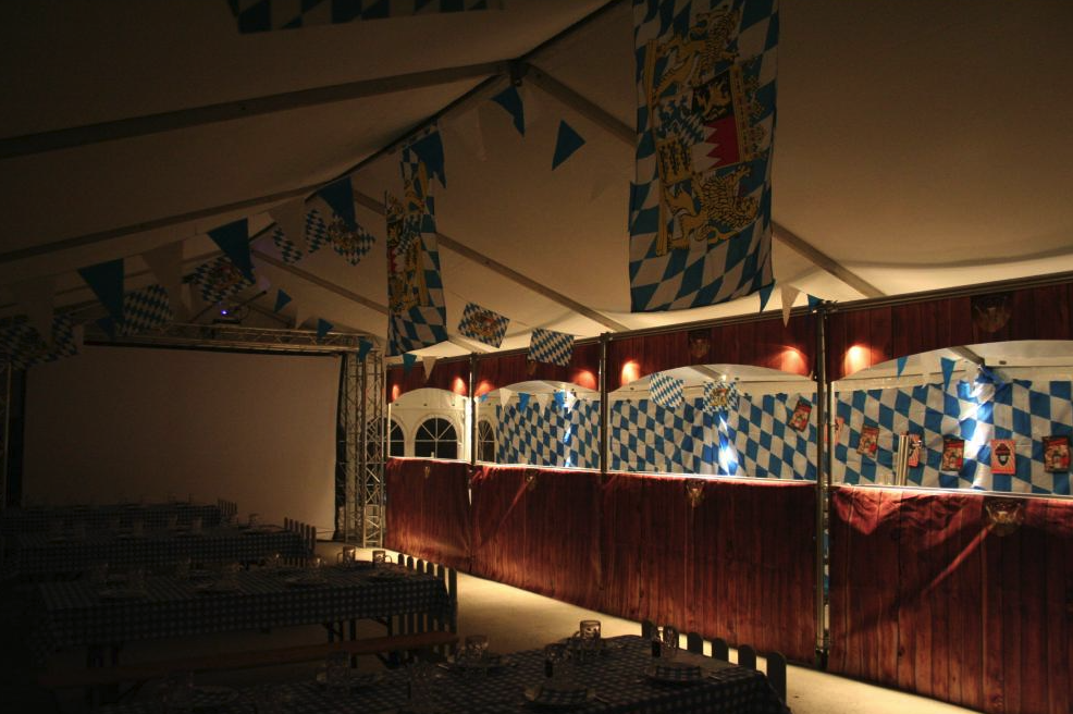 Eight shirts arranged on table in black, olive, grey, blue, white, red, mustard, and green.