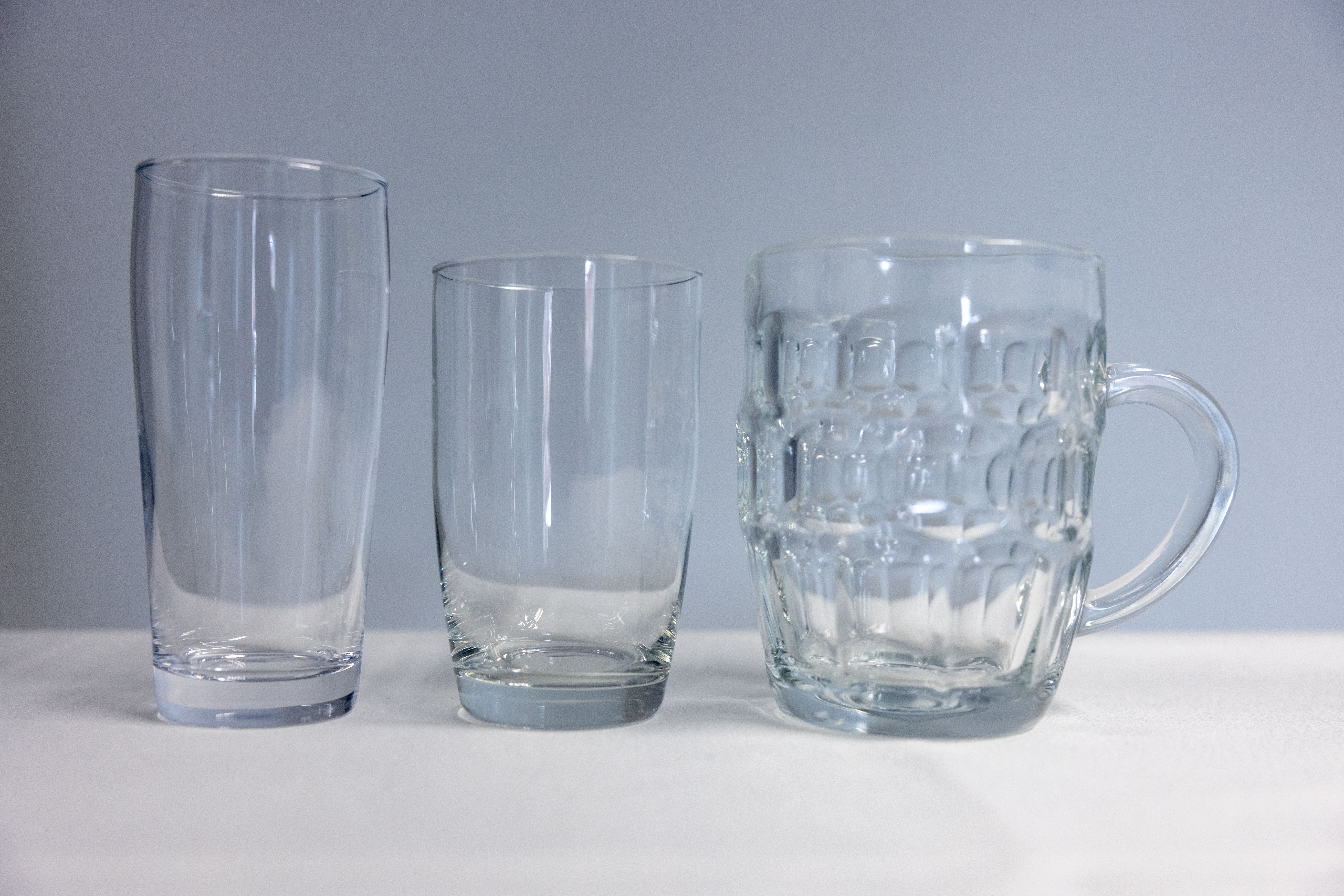 Eight shirts arranged on table in black, olive, grey, blue, white, red, mustard, and green.