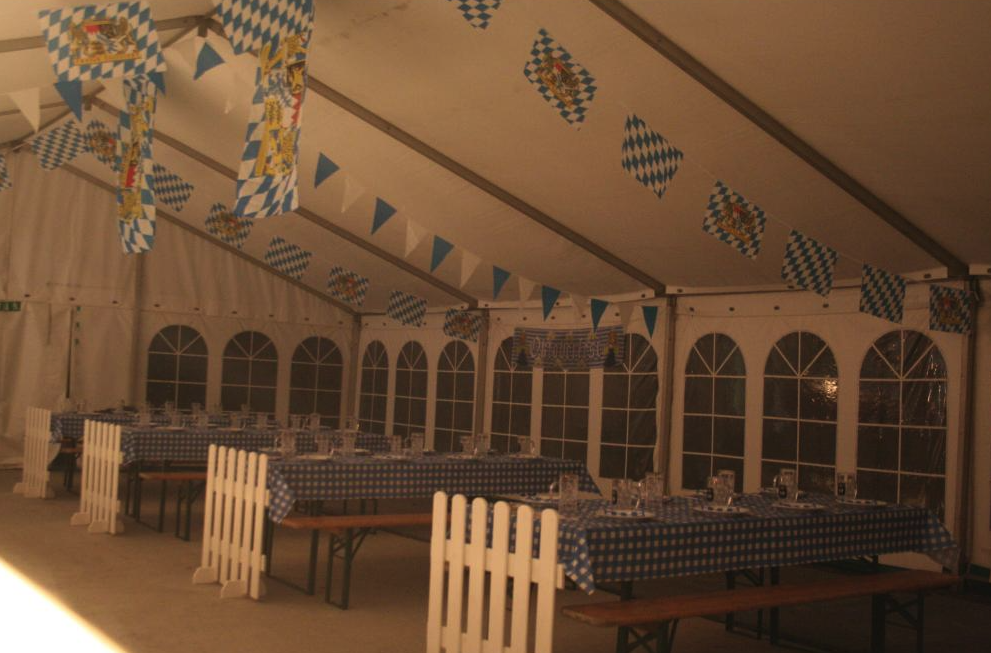 Eight shirts arranged on table in black, olive, grey, blue, white, red, mustard, and green.