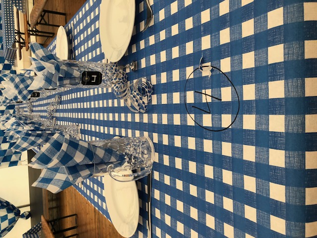 Eight shirts arranged on table in black, olive, grey, blue, white, red, mustard, and green.