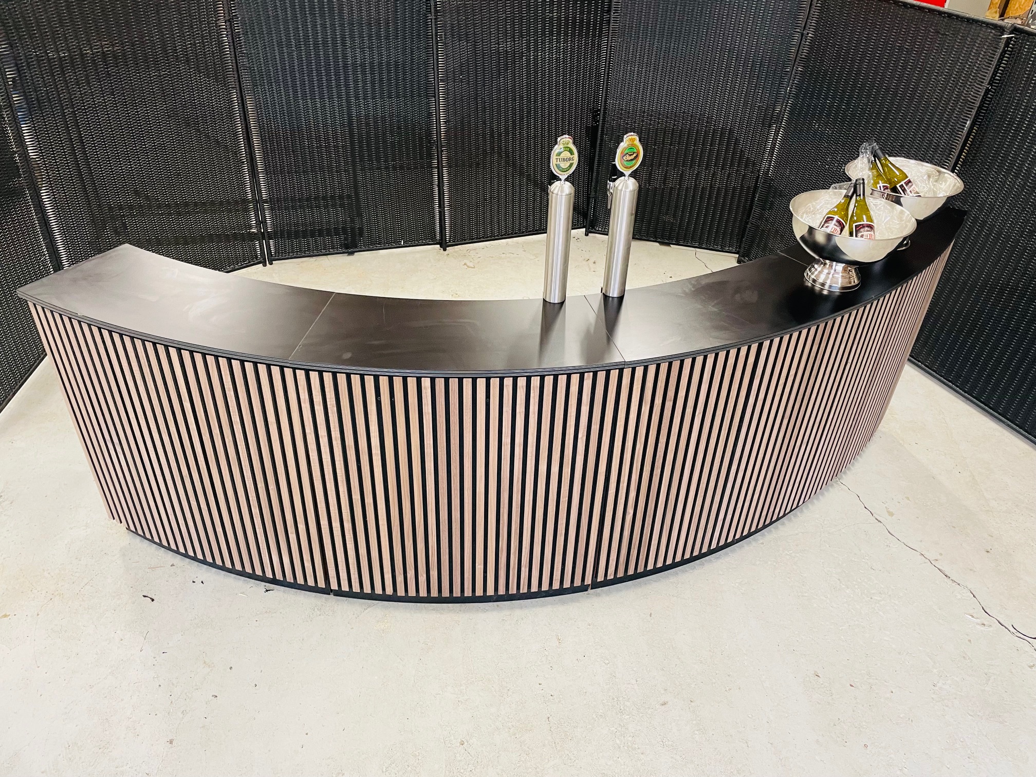 Eight shirts arranged on table in black, olive, grey, blue, white, red, mustard, and green.