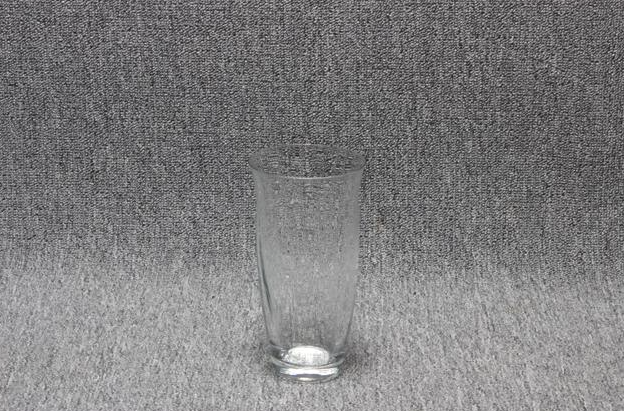 Eight shirts arranged on table in black, olive, grey, blue, white, red, mustard, and green.