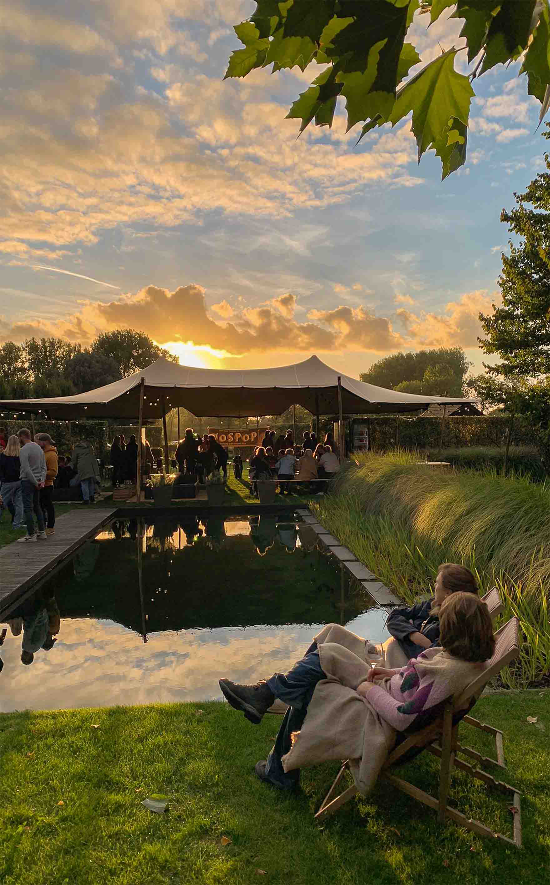 Eight shirts arranged on table in black, olive, grey, blue, white, red, mustard, and green.