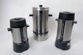 Eight shirts arranged on table in black, olive, grey, blue, white, red, mustard, and green.