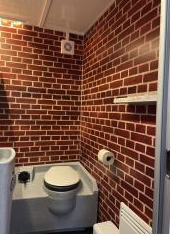 Eight shirts arranged on table in black, olive, grey, blue, white, red, mustard, and green.