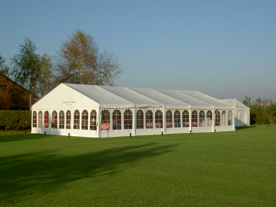 Eight shirts arranged on table in black, olive, grey, blue, white, red, mustard, and green.