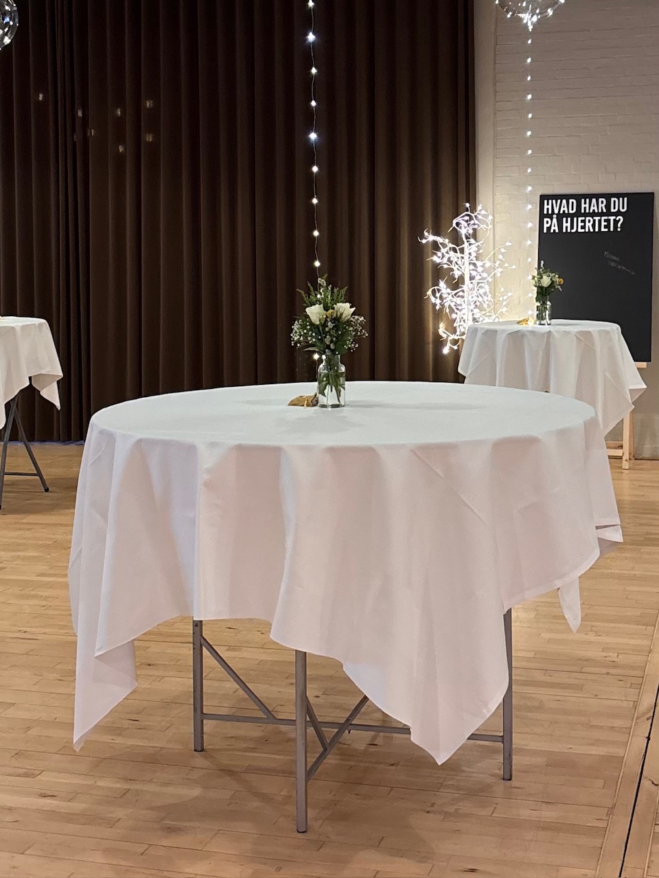 Eight shirts arranged on table in black, olive, grey, blue, white, red, mustard, and green.