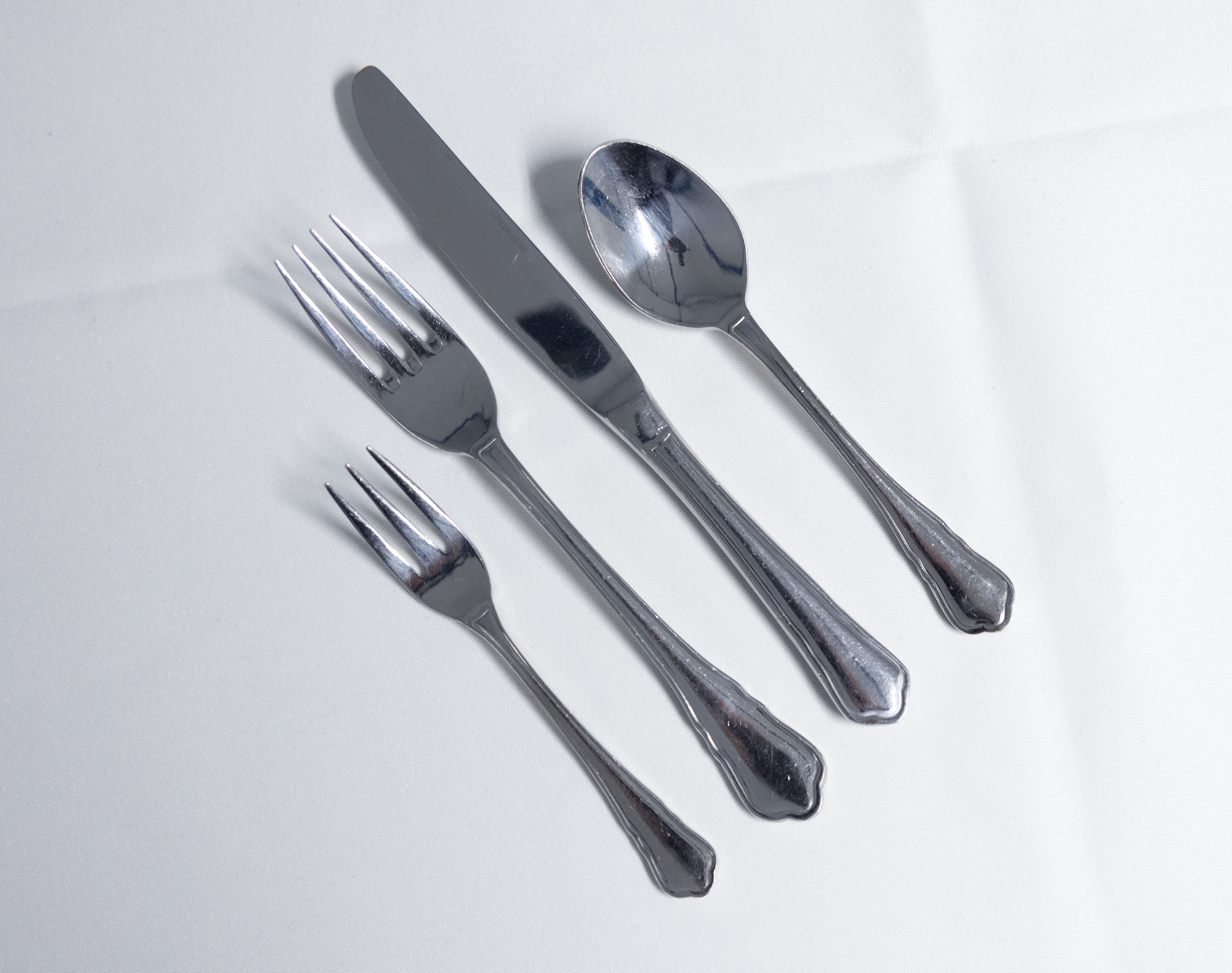 Eight shirts arranged on table in black, olive, grey, blue, white, red, mustard, and green.