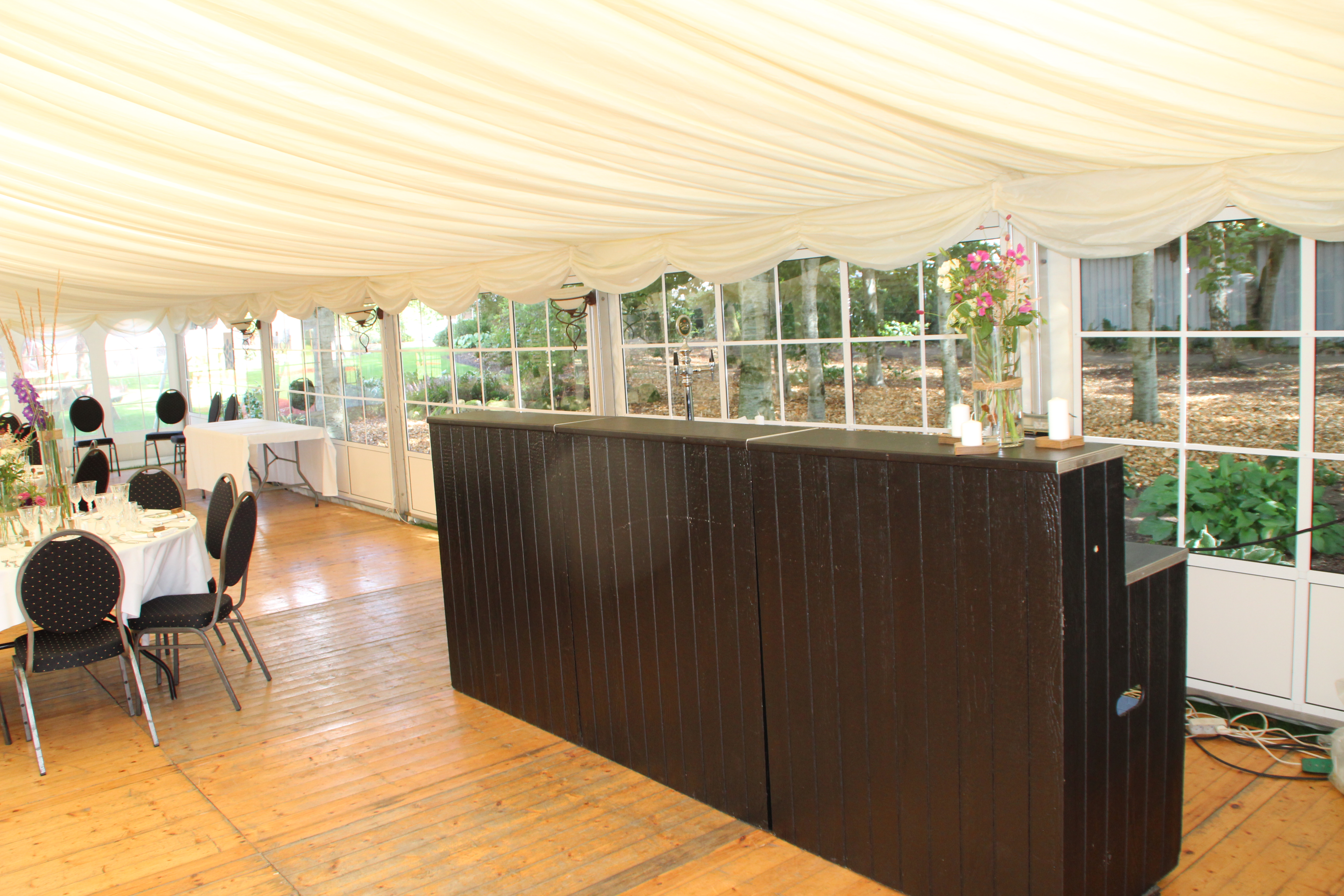 Eight shirts arranged on table in black, olive, grey, blue, white, red, mustard, and green.