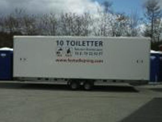 Eight shirts arranged on table in black, olive, grey, blue, white, red, mustard, and green.