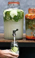 Eight shirts arranged on table in black, olive, grey, blue, white, red, mustard, and green.