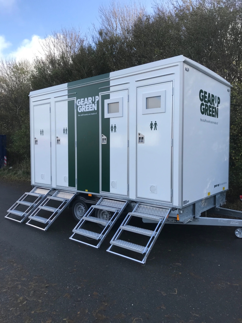 Eight shirts arranged on table in black, olive, grey, blue, white, red, mustard, and green.
