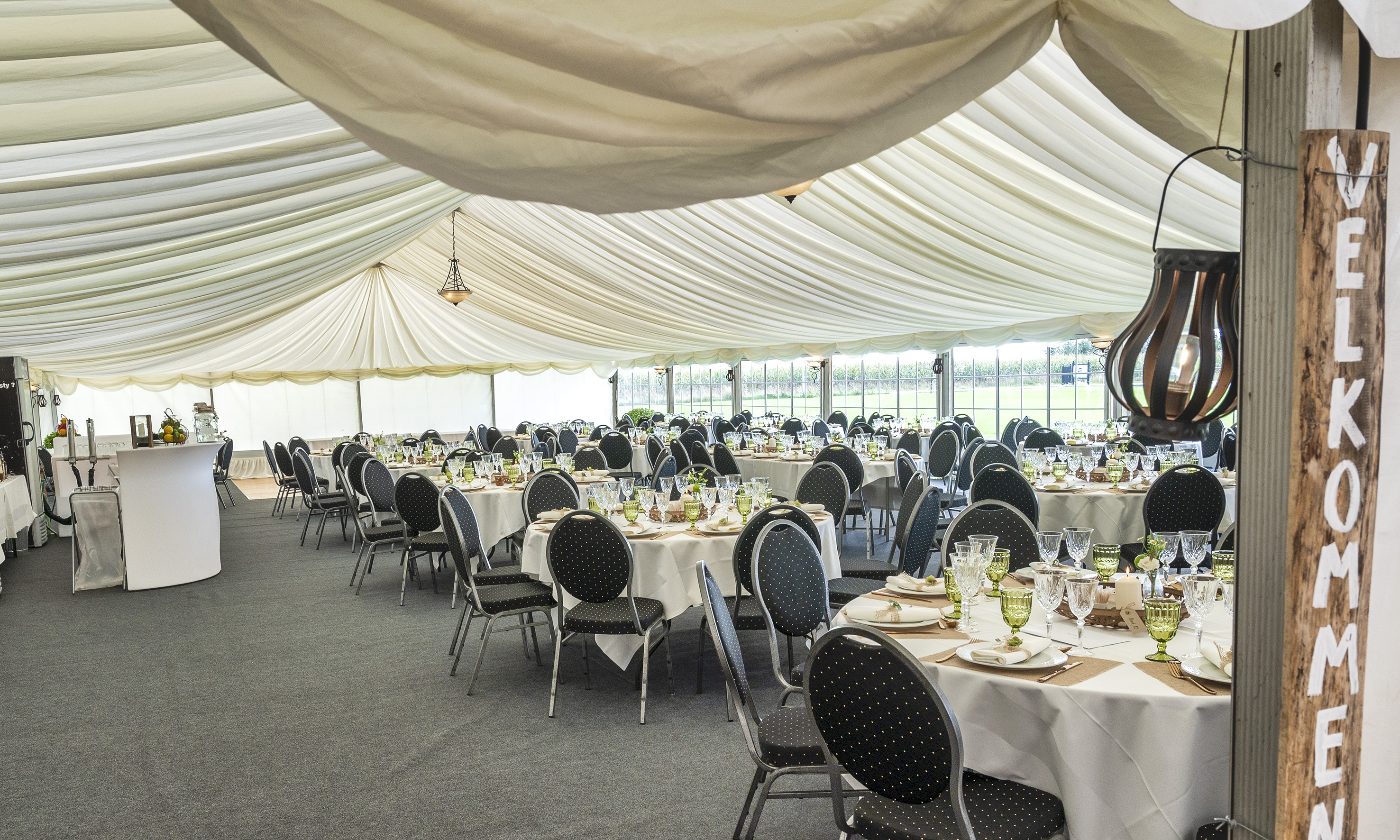 Eight shirts arranged on table in black, olive, grey, blue, white, red, mustard, and green.