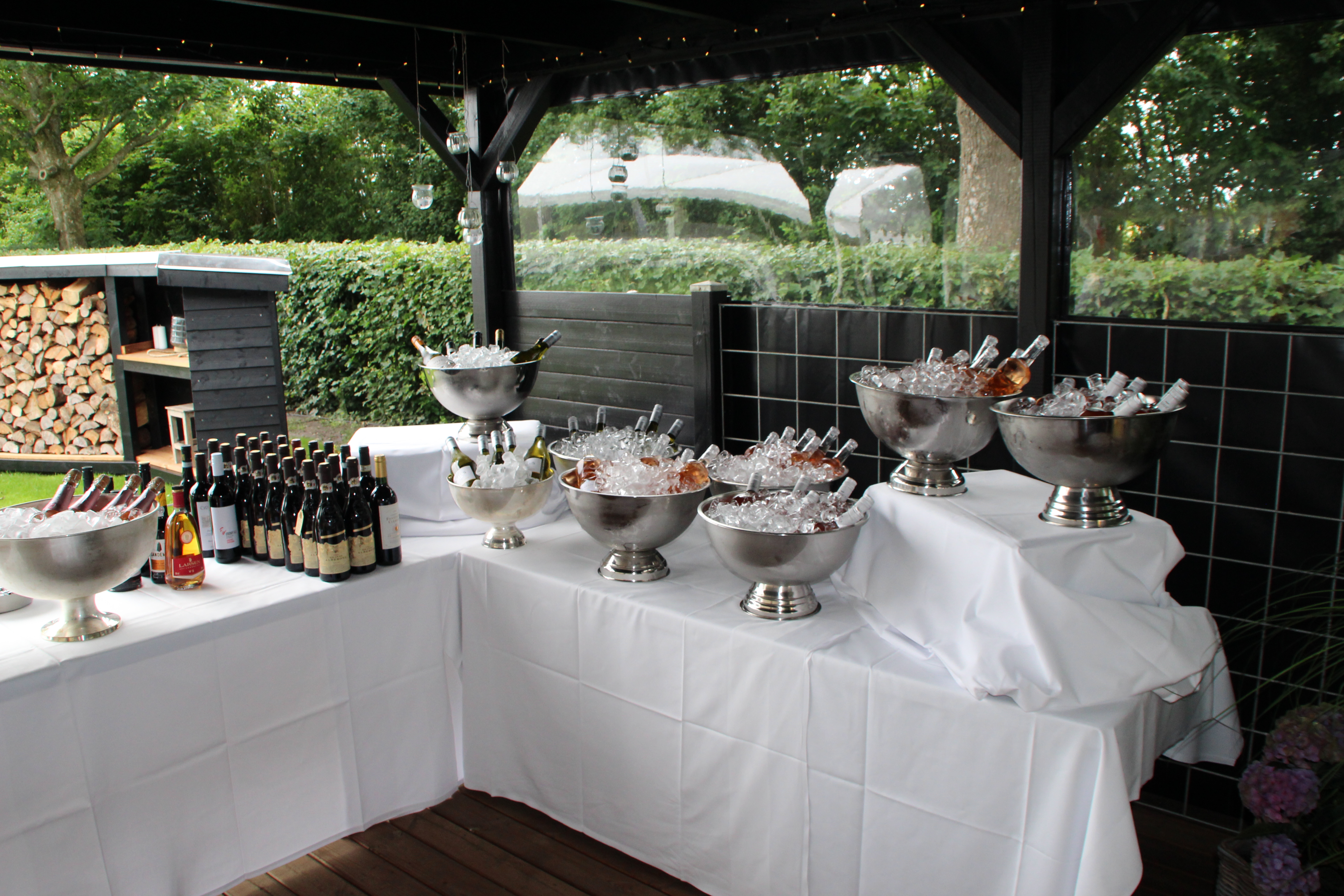 Eight shirts arranged on table in black, olive, grey, blue, white, red, mustard, and green.