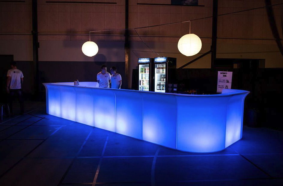 Eight shirts arranged on table in black, olive, grey, blue, white, red, mustard, and green.