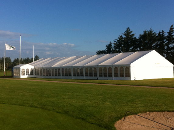 Eight shirts arranged on table in black, olive, grey, blue, white, red, mustard, and green.